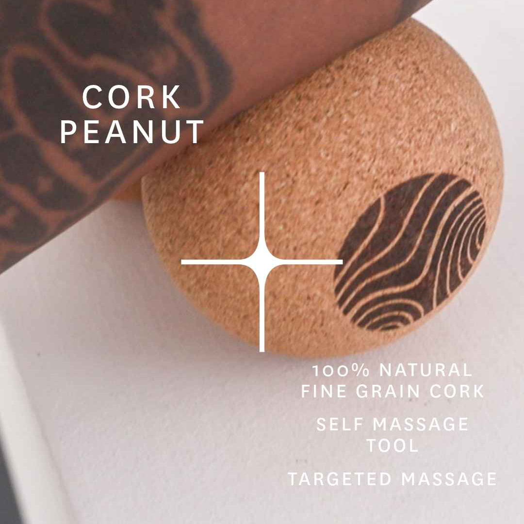 A close-up of a cork massage tool shaped like a peanut, shown resting on a white surface with a tattooed arm pressing down on it. White text reads 'CORK PEANUT' and additional product text appears below.